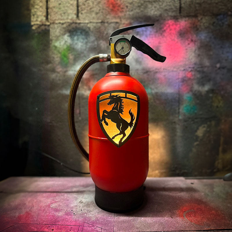 Fire extinguisher upcycled in a an automotive decoration lamp. Handpainted in red by Jean-Luc Rossier (JLR Concept) customized with the Ferrari logo. Front view with yellow light.