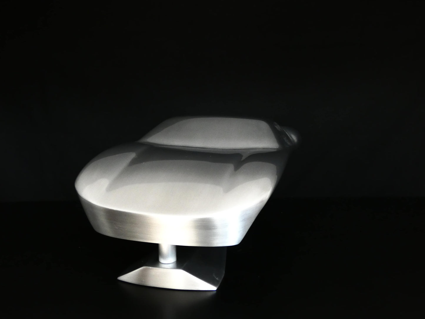 Metal sheet automotive sculpture with raw aluminium representing a Ford GT40 evocation, created by Frédéric Girard, limited edition of 8, 45x19 cm format. Front view showcasing the iconic curves and the meticulous attention to each sculpted detail, a collector’s piece for automotive and fine craftsmanship enthusiasts.