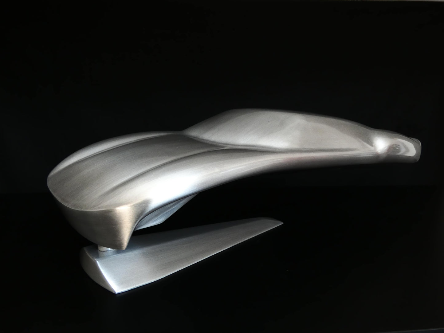 Metal sheet automotive sculpture with raw aluminium representing a Ford GT40 evocation, created by Frédéric Girard, limited edition of 8, 45x19 cm format. Side 3/4 view showcasing the iconic curves and the meticulous attention to each sculpted detail, a collector’s piece for automotive and fine craftsmanship enthusiasts.