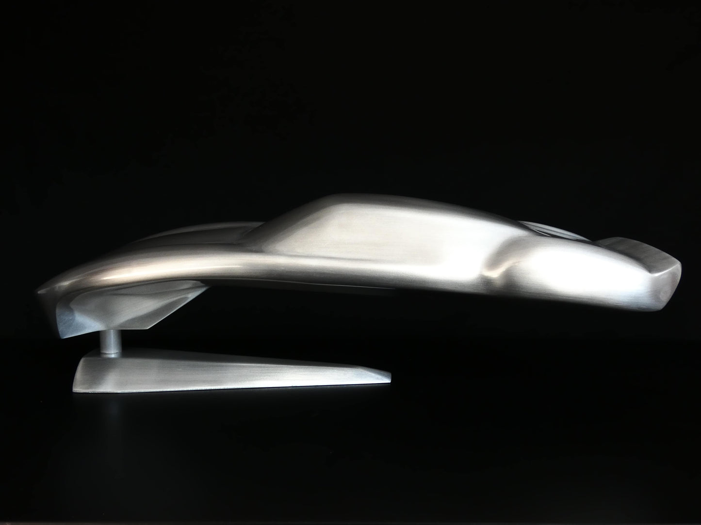 Metal sheet automotive sculpture with raw aluminium representing a Ford GT40 evocation, created by Frédéric Girard, limited edition of 8, 45x19 cm format. Side view showcasing the iconic curves and the meticulous attention to each sculpted detail, a collector’s piece for automotive and fine craftsmanship enthusiasts.