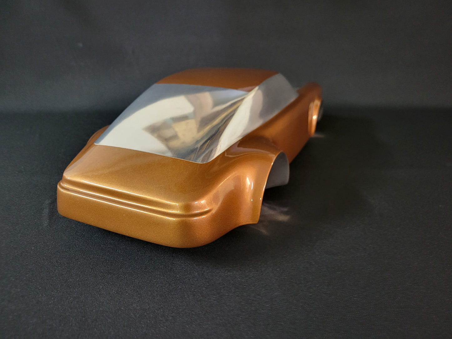 Metal sheet automotive sculpture with silver and gold finish representing a Porsche 911 Flat 6, created by Frédéric Girard, limited edition of 8, 58x25 cm format. Tail view showcasing the iconic curves and the meticulous attention to each sculpted detail, a collector’s piece for automotive and fine craftsmanship enthusiasts.