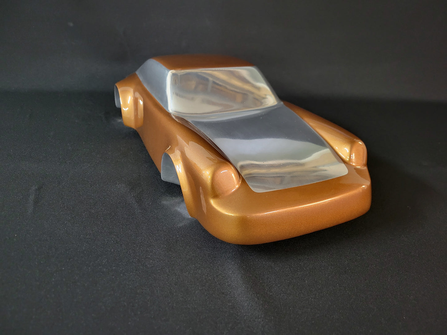 Metal sheet automotive sculpture with silver and gold finish representing a Porsche 911 Flat 6, created by Frédéric Girard, limited edition of 8, 58x25 cm format. Top 3/4 view showcasing the iconic curves and the meticulous attention to each sculpted detail, a collector’s piece for automotive and fine craftsmanship enthusiasts.