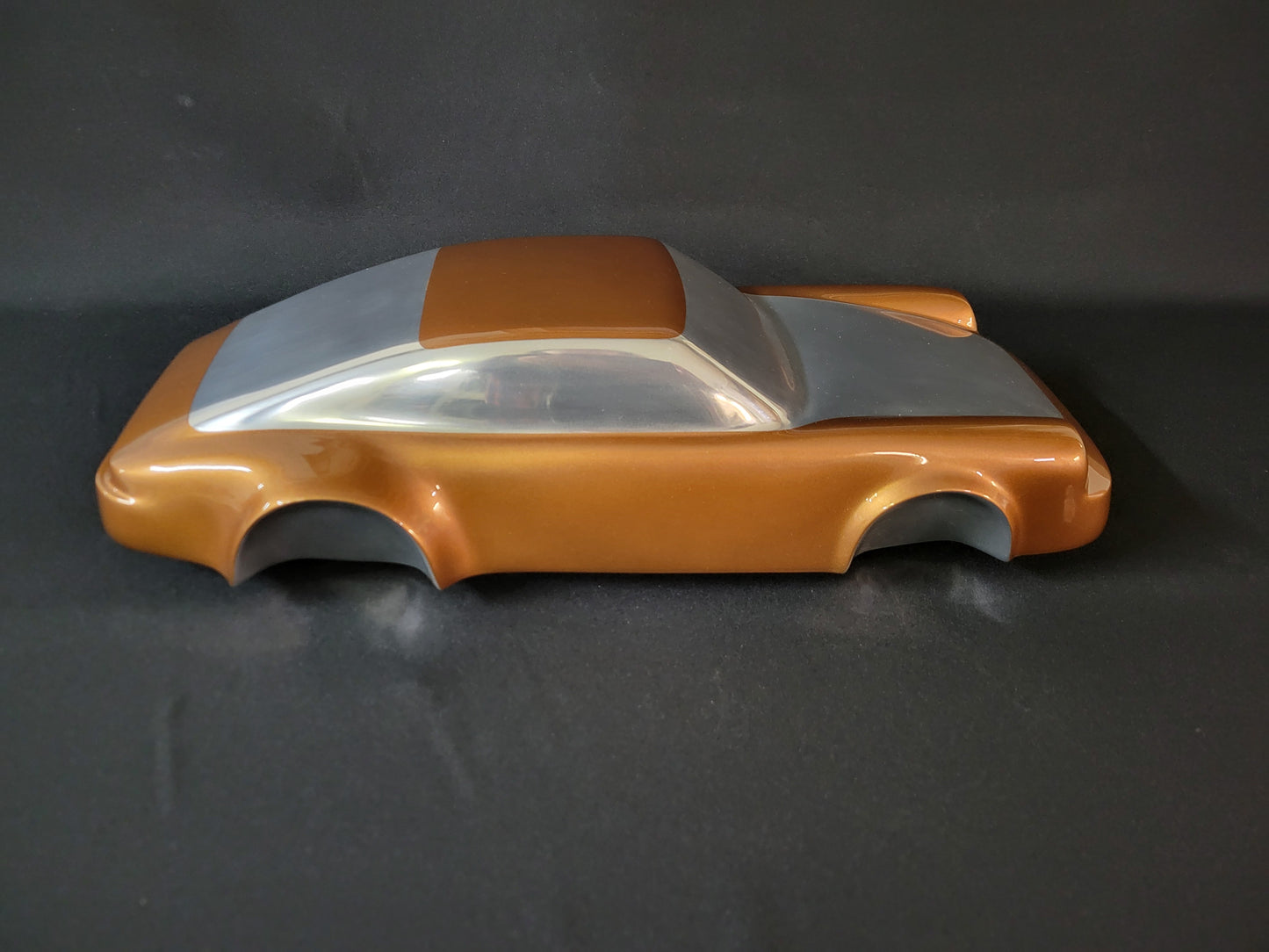 Metal sheet automotive sculpture with silver and gold finish representing a Porsche 911 Flat 6, created by Frédéric Girard, limited edition of 8, 58x25 cm format. Side view showcasing the iconic curves and the meticulous attention to each sculpted detail, a collector’s piece for automotive and fine craftsmanship enthusiasts.