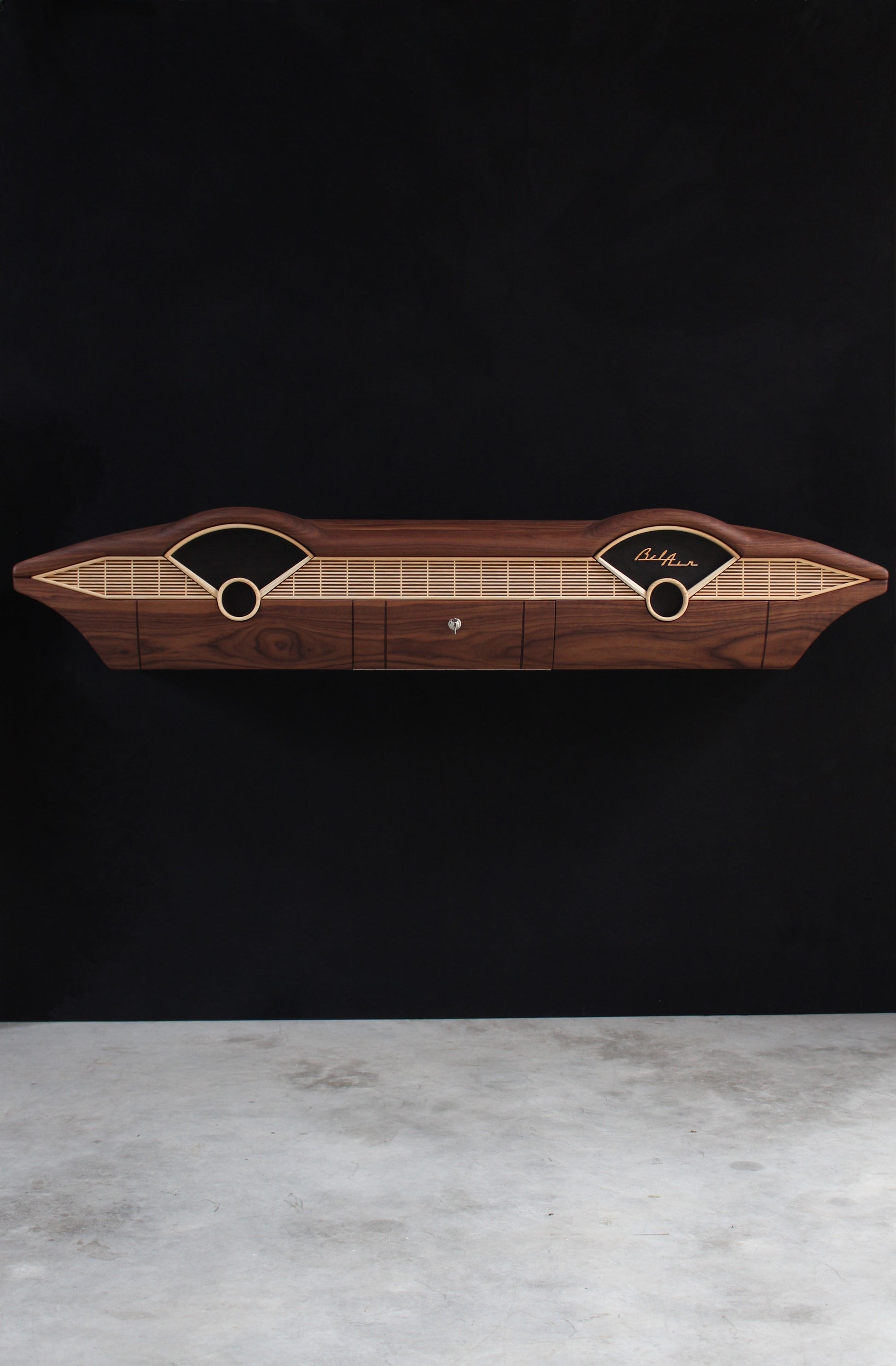 Solid wood furniture representing a Chevrolet Bel Air console, created by Stéphane Carton from Atelier Stéphane Carton, woodworker & cabinetmaker.

Limited edition of 25, 164 x 30 x 30 cm, handcrafted solid American walnut and ash structure, swamp oak veneer (fronts), oiled finish, hand application. Personalization possible.

Perfect for vintage automotive design lovers, classic cars enthusiasts and Chevrolet owners. Front full view.
