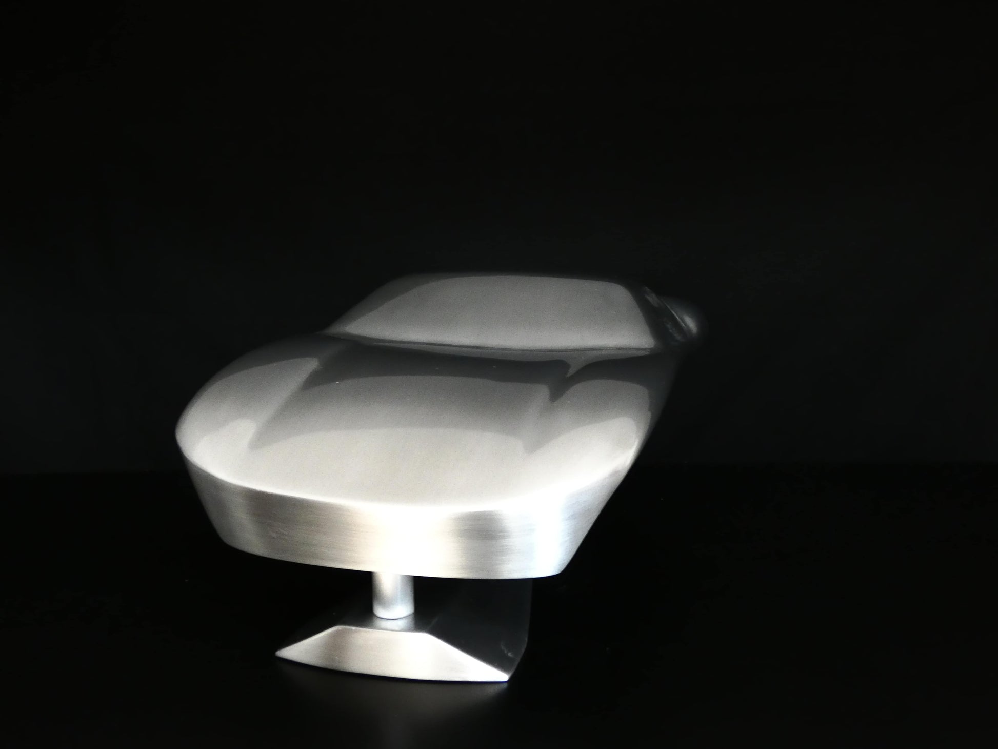 Metal sheet automotive sculpture with raw aluminium representing a Ford GT40 evocation, created by Frédéric Girard, limited edition of 8, 45x19 cm format. Front view showcasing the iconic curves and the meticulous attention to each sculpted detail, a collector’s piece for automotive and fine craftsmanship enthusiasts.