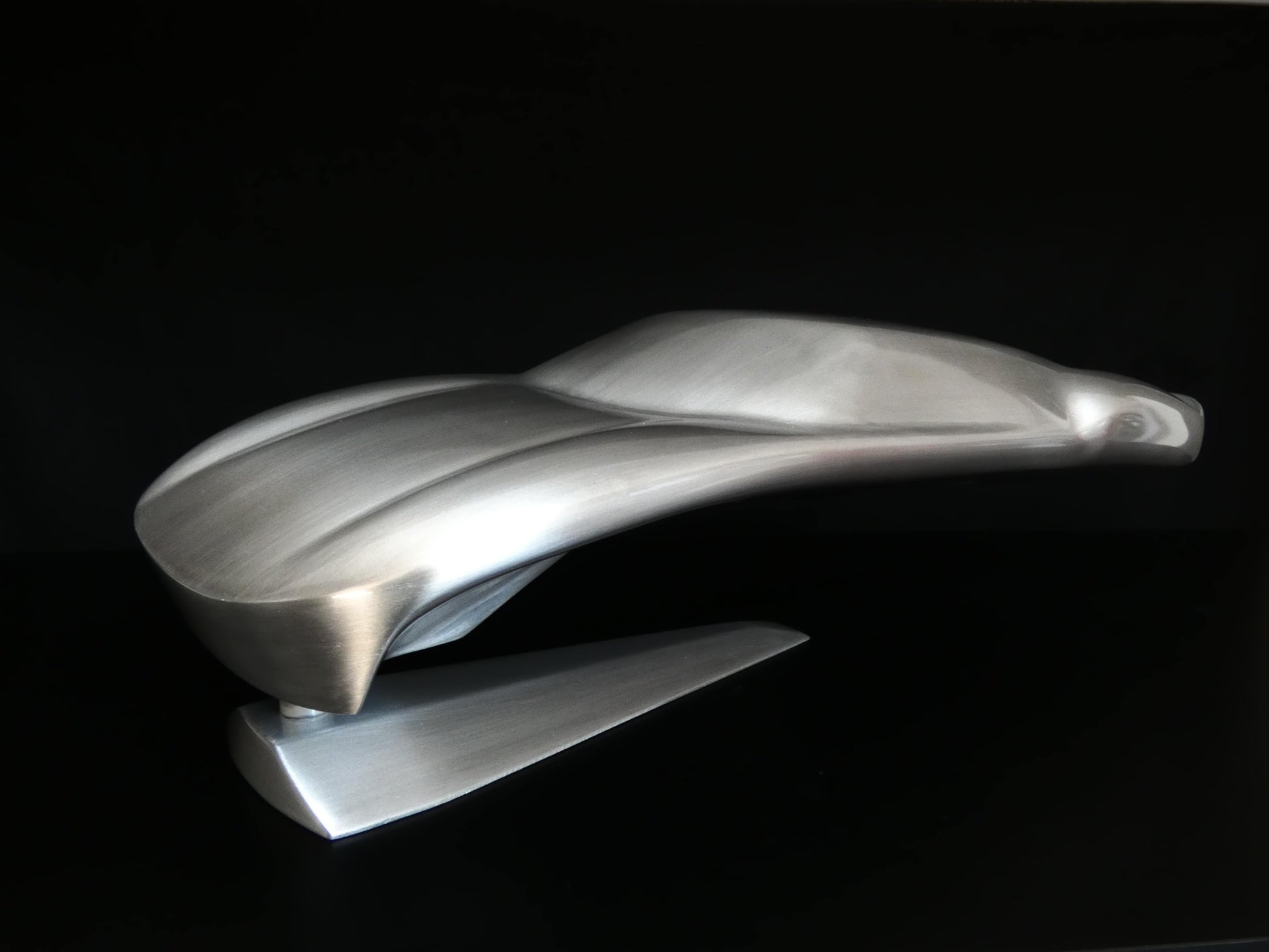 Metal sheet automotive sculpture with raw aluminium representing a Ford GT40 evocation, created by Frédéric Girard, limited edition of 8, 45x19 cm format. Side 3/4 view showcasing the iconic curves and the meticulous attention to each sculpted detail, a collector’s piece for automotive and fine craftsmanship enthusiasts.