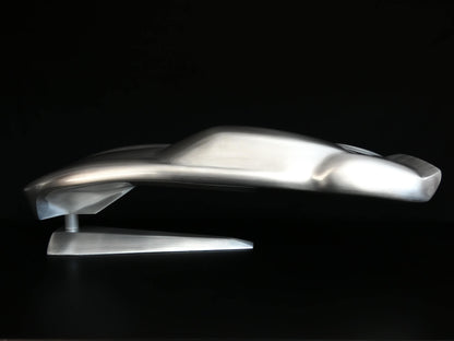 Metal sheet automotive sculpture with raw aluminium representing a Ford GT40 evocation, created by Frédéric Girard, limited edition of 8, 45x19 cm format. Side view showcasing the iconic curves and the meticulous attention to each sculpted detail, a collector’s piece for automotive and fine craftsmanship enthusiasts.