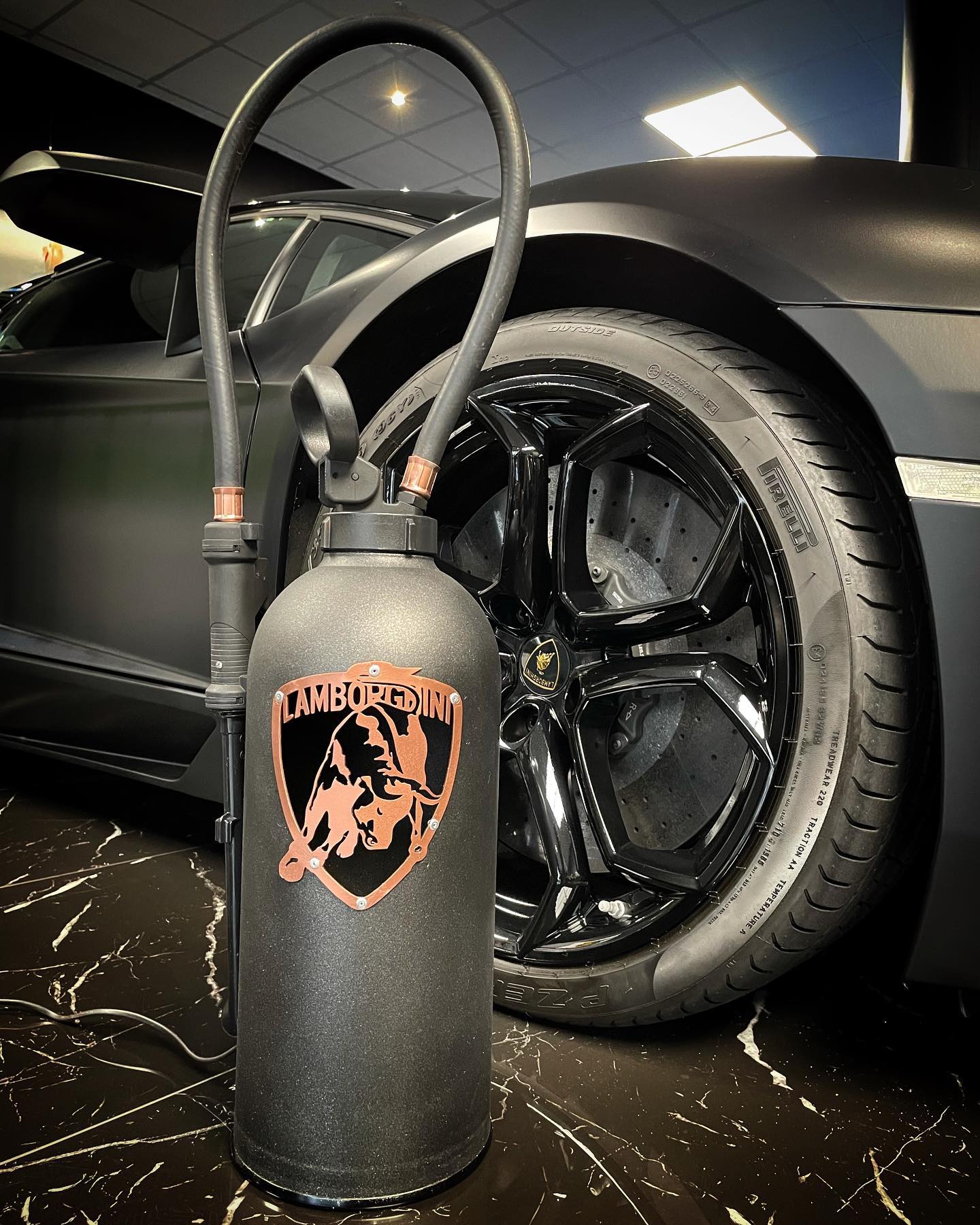 Fire extinguisher upcycled in an automotive decoration lamp. Handpainted in black by Jean-Luc Rossier (JLR Concept) customized with the Lamborghini logo. Wheel view with no light.
