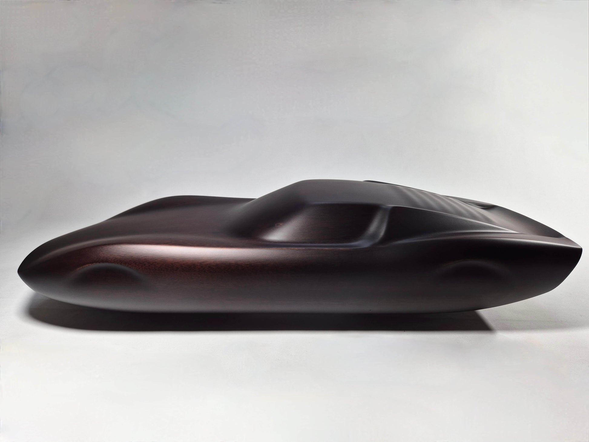 Solid mahogany sculpture with ebony matte finish representing a Lamborghini Miura, created by David Voisin from Maison V&P, limited edition, 30x66 cm. Left side view showcasing the iconic curves and sculpted silhouette of this legendary supercar, a collector’s piece for automotive and fine craftsmanship enthusiasts.