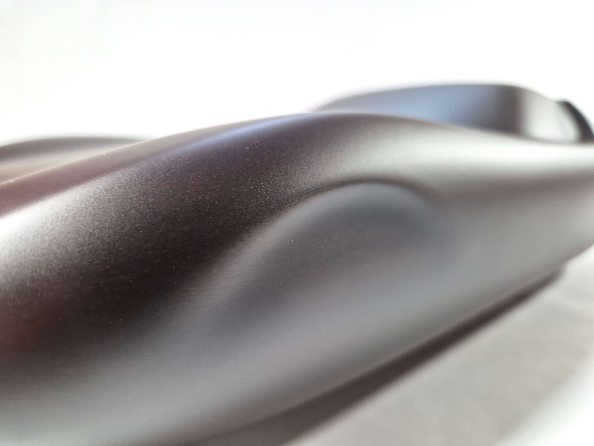 Solid mahogany sculpture with ebony matte finish representing a Lamborghini Miura, created by David Voisin from Maison V&P, limited edition, 30x66 cm. Close-up of the wheel highlighting the precision of craftsmanship and attention to sculpted details, a collector’s piece for automotive and fine craftsmanship enthusiasts.