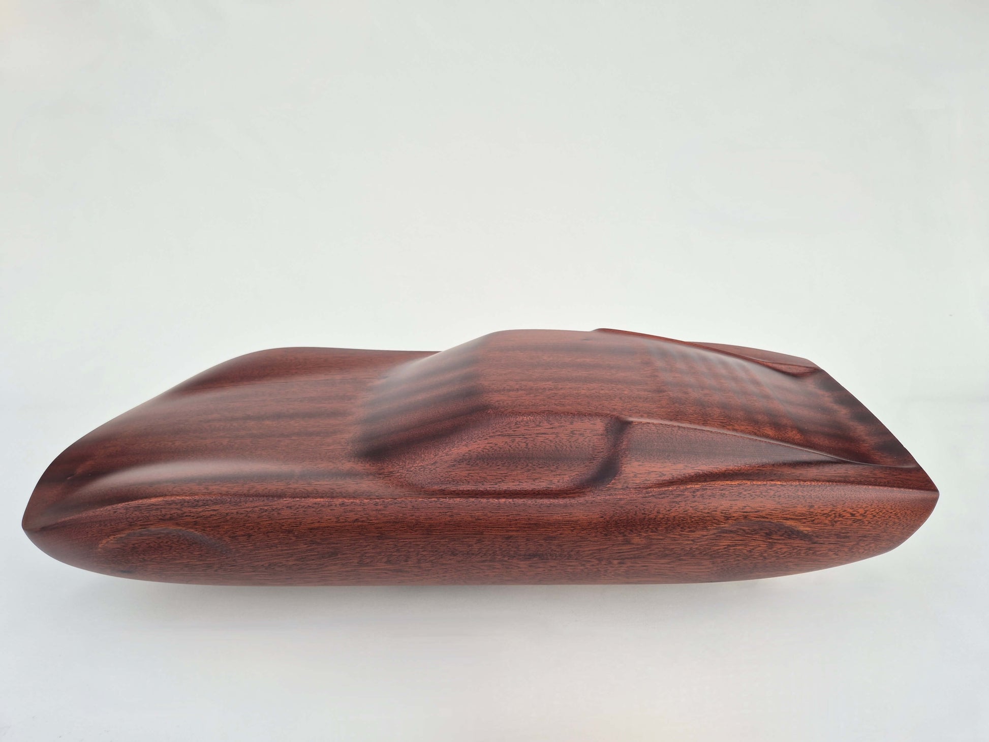 Solid mahogany sculpture with natural matte finish representing a Lamborghini Miura, created by David Voisin from Maison V&P, limited edition, 30x66 cm format. Left side view highlighting the iconic curves and refined sculpted details of this legendary supercar, a collector’s piece for automotive and fine craftsmanship enthusiasts.