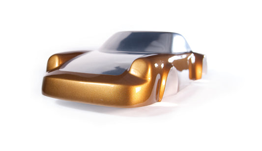 Metal sheet automotive sculpture with silver and gold finish representing a Porsche 911 Flat 6, created by Frédéric Girard, limited edition of 8, 58x25 cm format. Nose 3/4 view showcasing the iconic curves and the meticulous attention to each sculpted detail, a collector’s piece for automotive and fine craftsmanship enthusiasts.