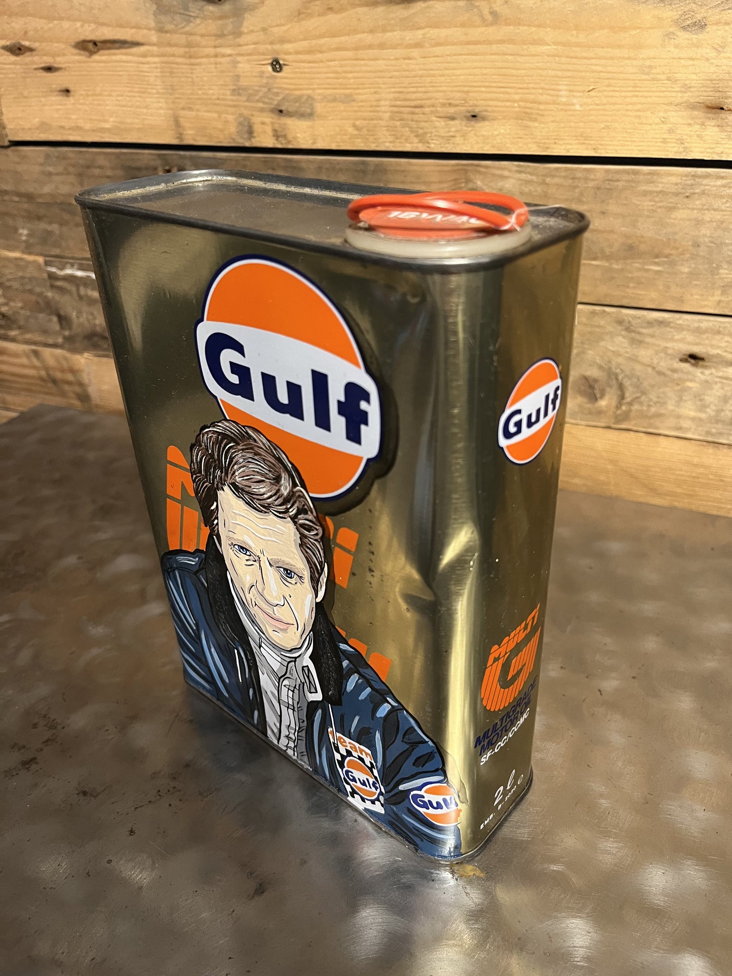 Steve McQueen Gulf hand-painted custom vintage automotive vintage automotive oil can, created by Mathieu Ollevier from Vintage Addict, limited edition of 10, 23x17 cm format. Left view showcasing the handpainted detail, a collector’s piece for automotive, vintage and art enthusiasts.